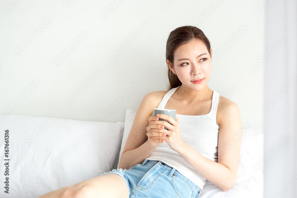 Woman wake up happy in bed, drinking coffee with fresh feeling in the morning