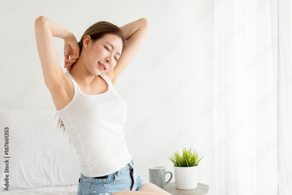 Young asian woman wake up happy, stretching arms hands and feeling fresh in the morning