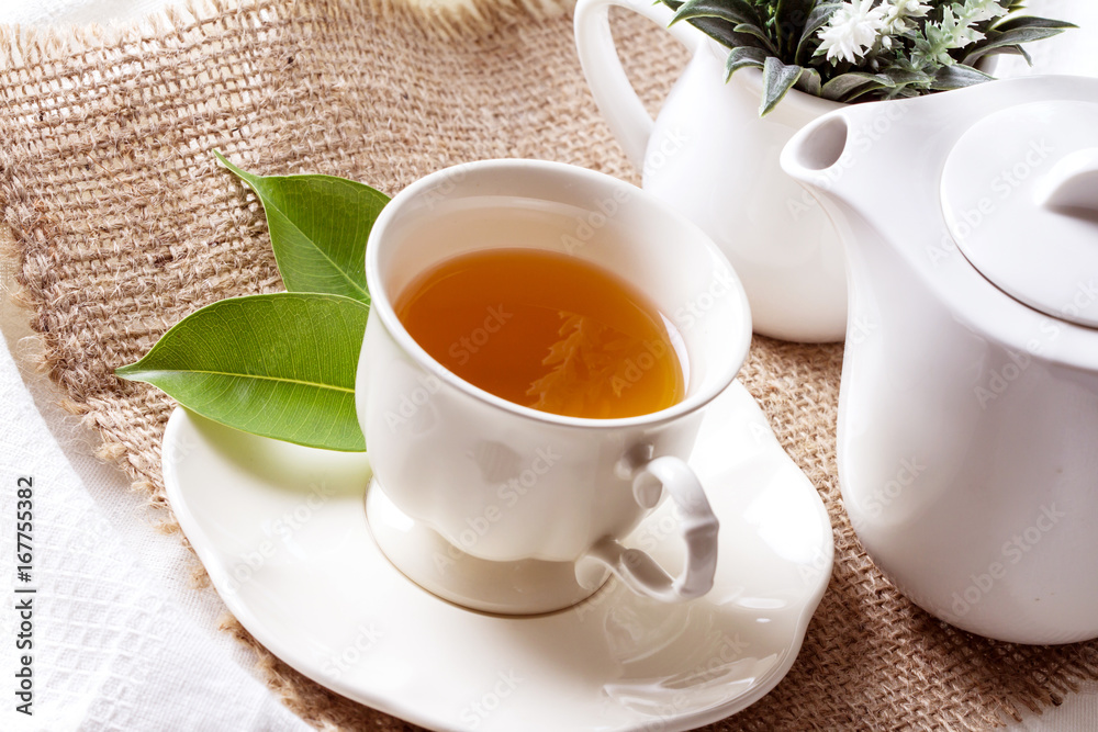 Close up organic tea in white cup with green leaf , Tea ceremony time concept