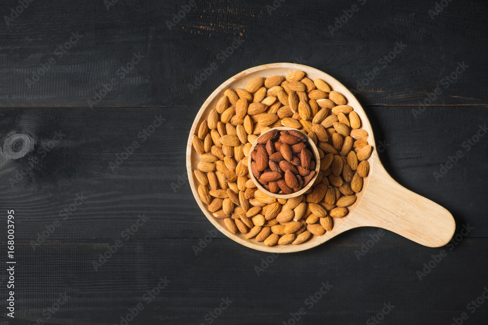 Almonds in bowl on wooden table. Almond nuts.