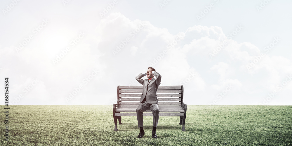 Young man in suit in park dont want to hear anything