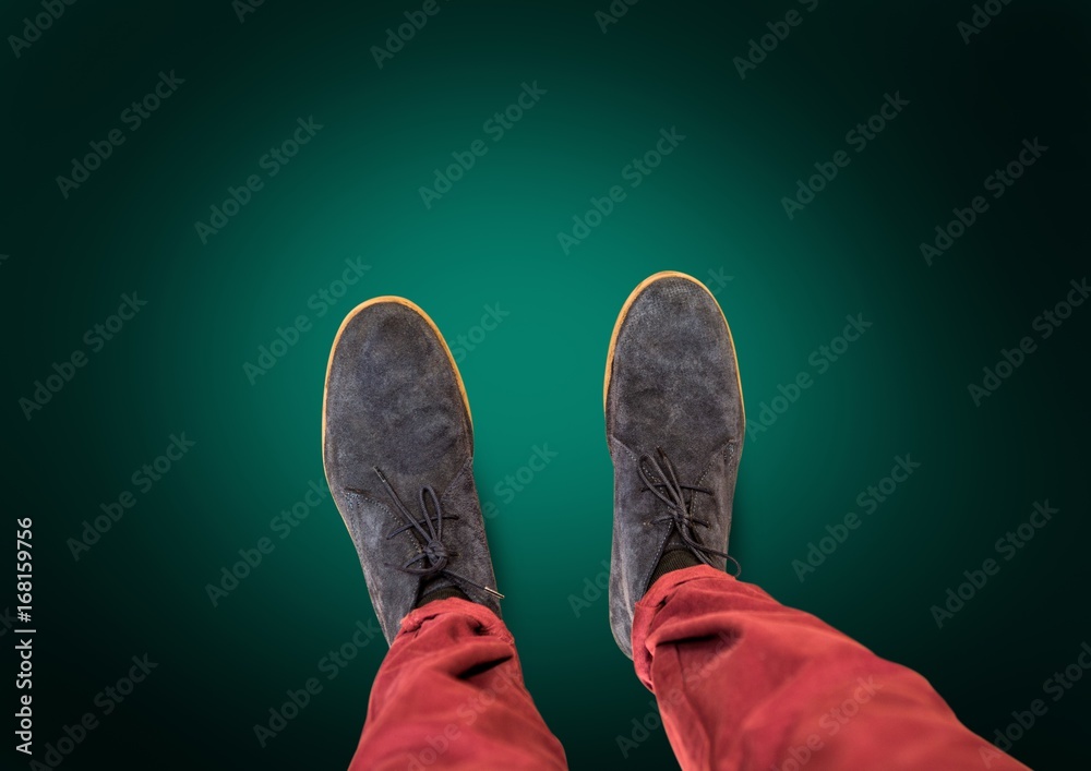 Grey shoes on feet with green background