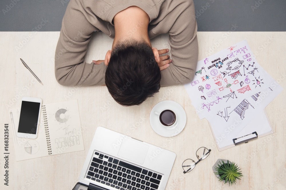 Young businessman sleeping in front of computer at desk