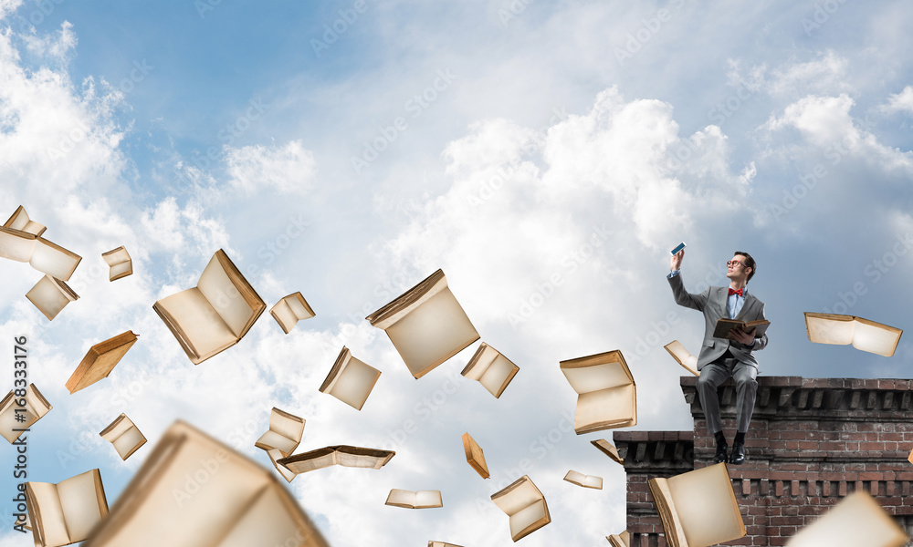 Young businessman or student studying the science and books flying around