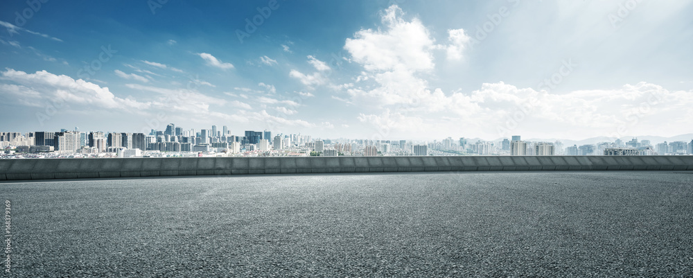 empty road and cityscape of modern city against cloud sky