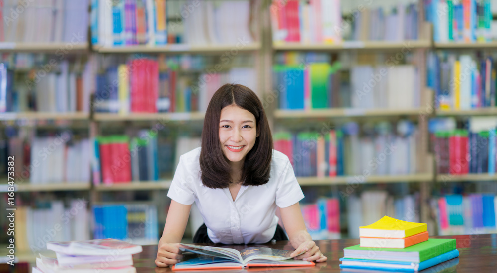 亚洲女学生在大学校园图书馆看书