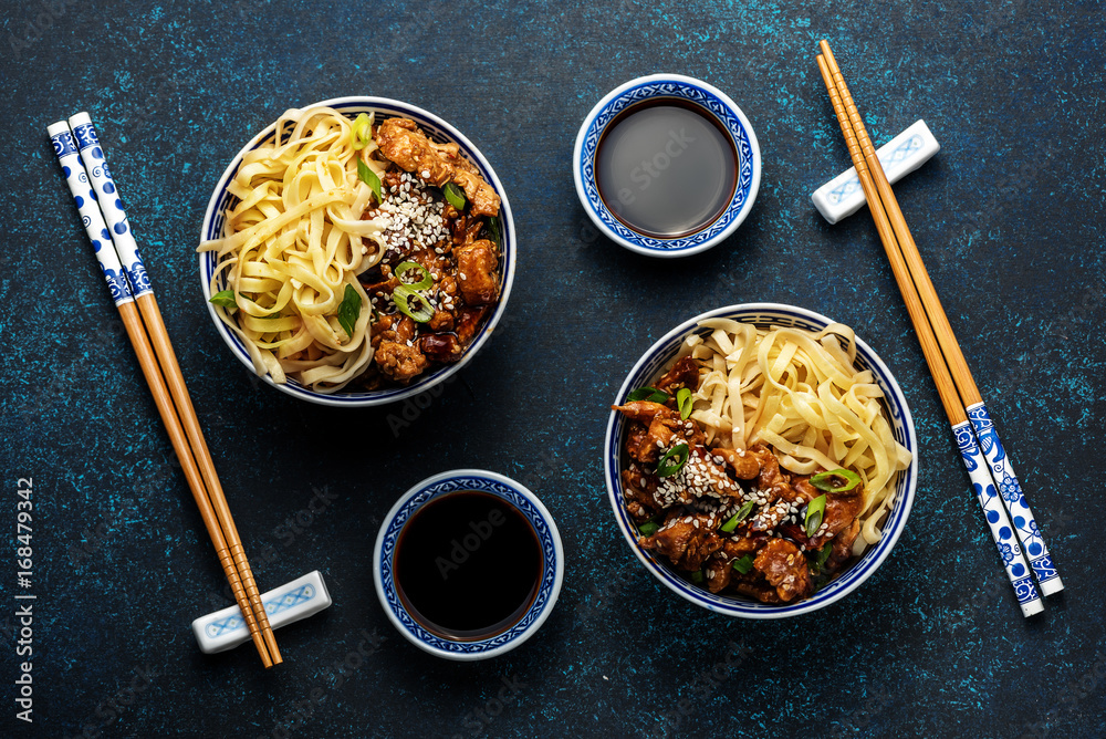 Chicken teriyaki on dark background with balsamic sauce and sesame seeds. Asian food. Noodles, chick