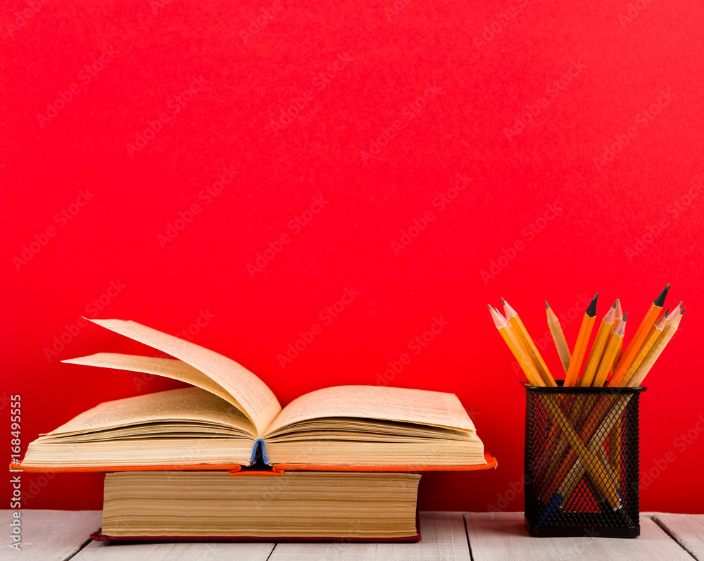 education and wisdom concept - open book on wooden table, color background