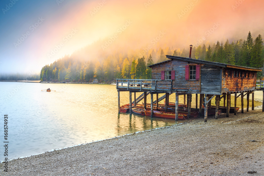 Wooden boathouse with boats on the alpine lake, Dolomites, Italy