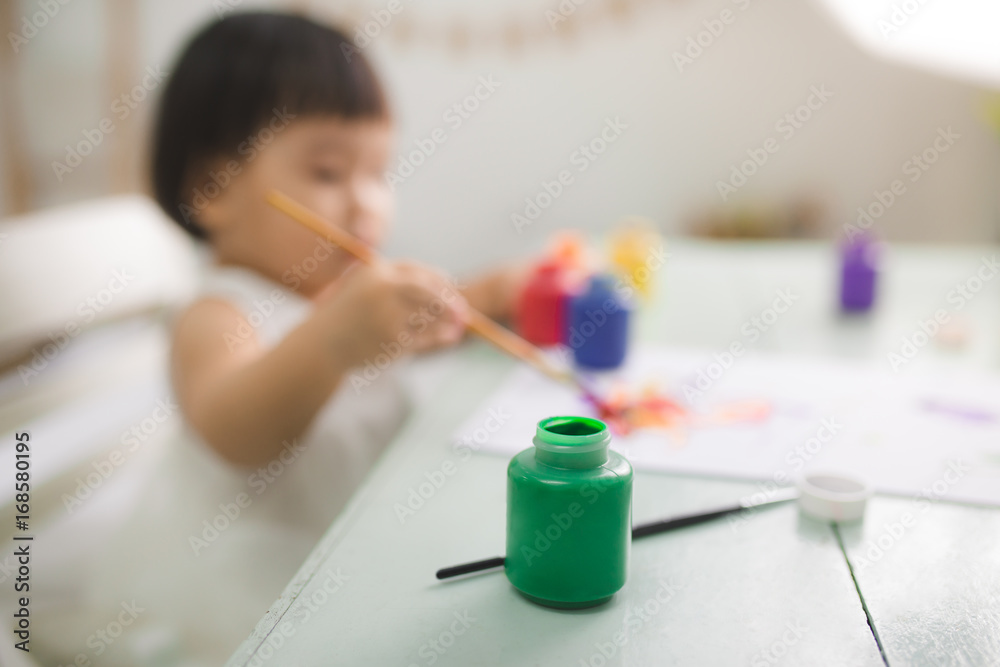 有趣的亚洲女婴在家用彩色铅笔画画