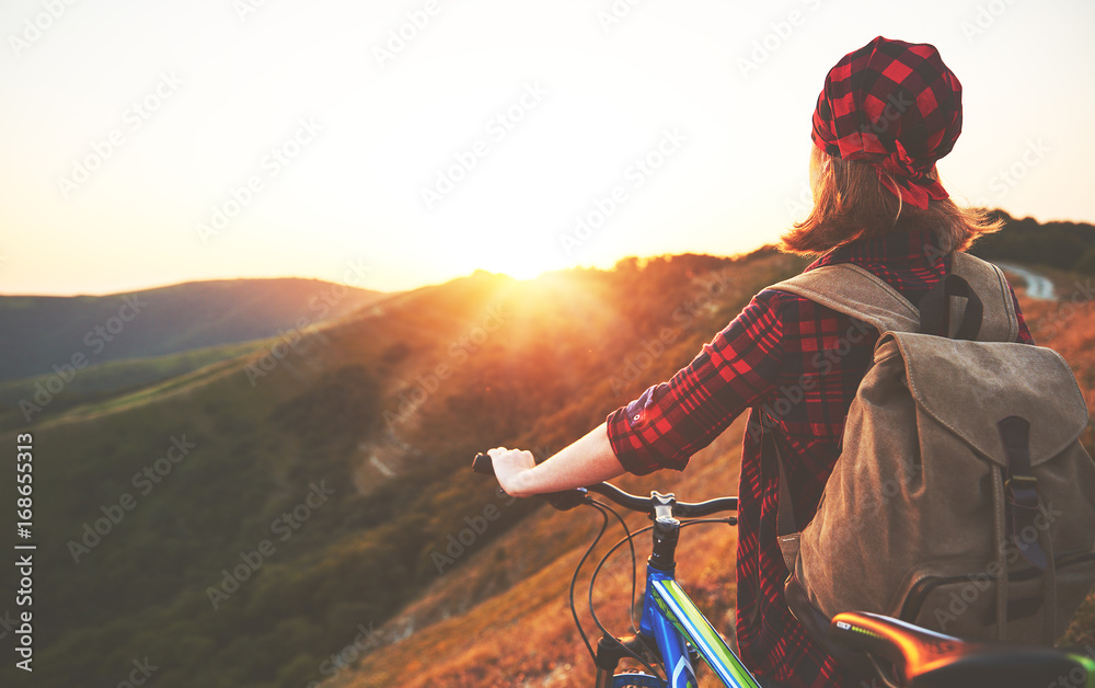 夏季户外徒步旅行日落时骑自行车在山顶的女游客