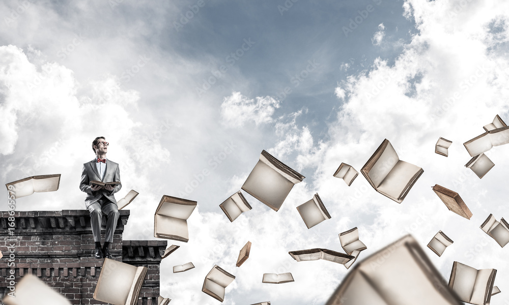 Young businessman or student studying the science and books flyi