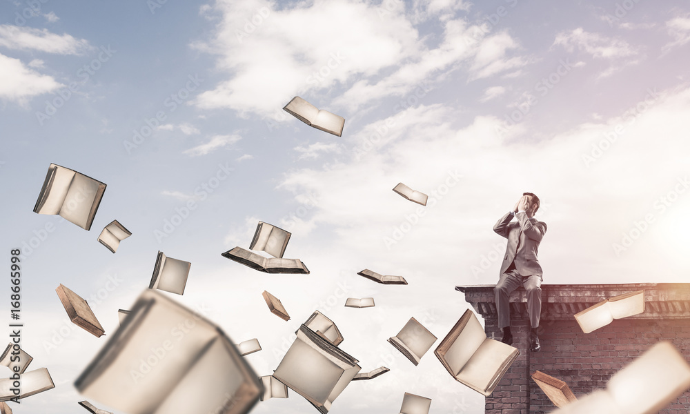 Young man sitting on roof edge and do not want to see anything