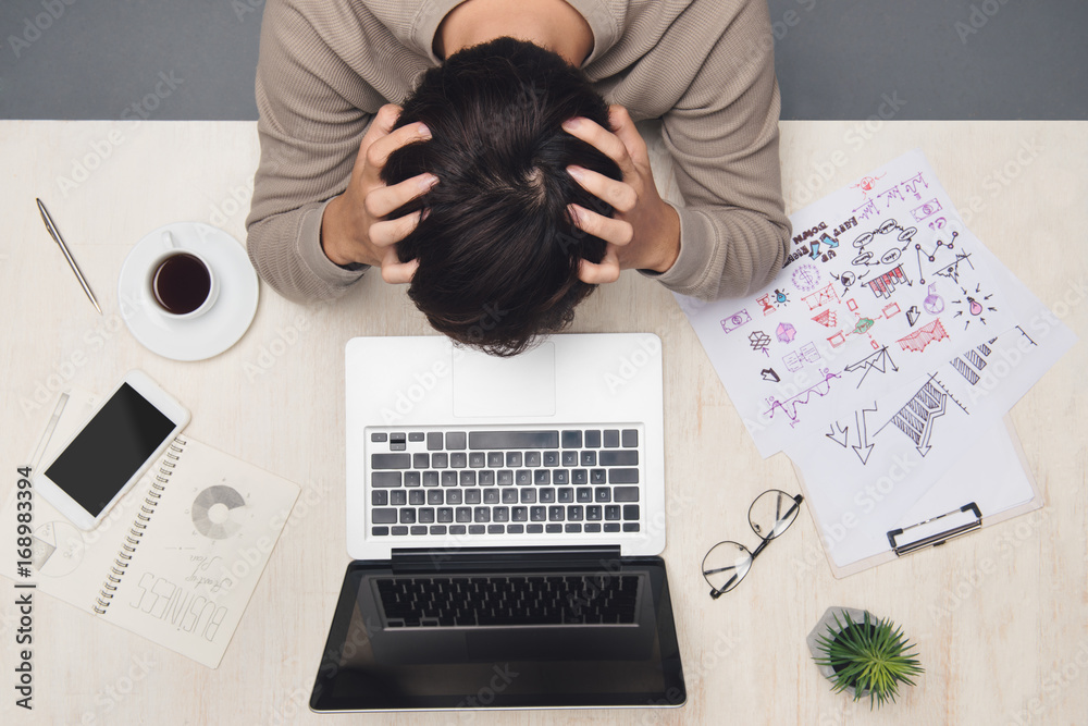 Stressed businessman working on desk at workplace