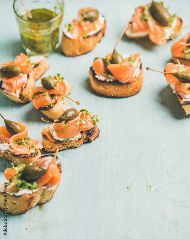 Crostini配烟熏三文鱼、香蒜酱、豆瓣菜和山柑，浅蓝色背景，精选