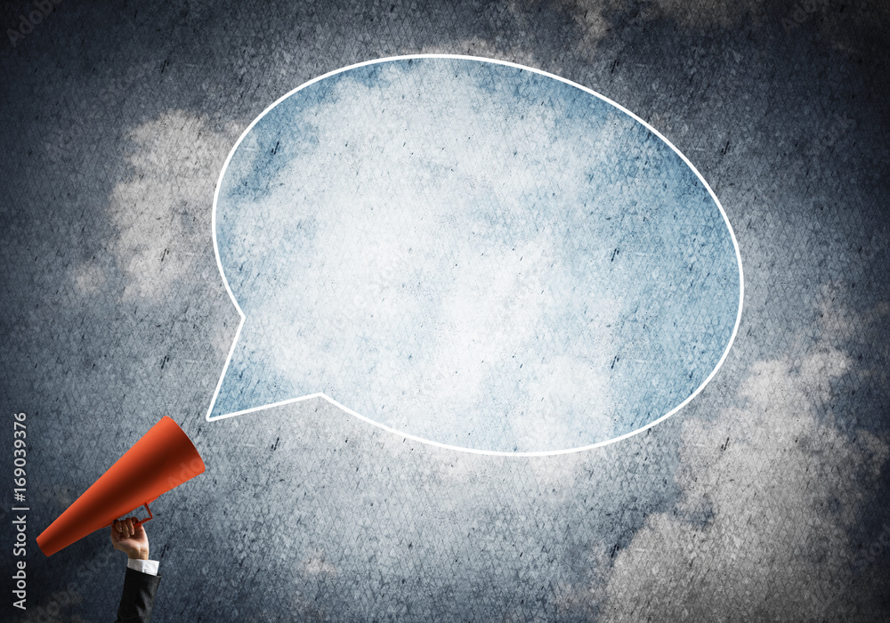 Hand of businesswoman holding red paper trumpet and speech cloud