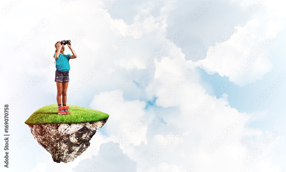 Concept of careless happy childhood with girl looking in binoculars