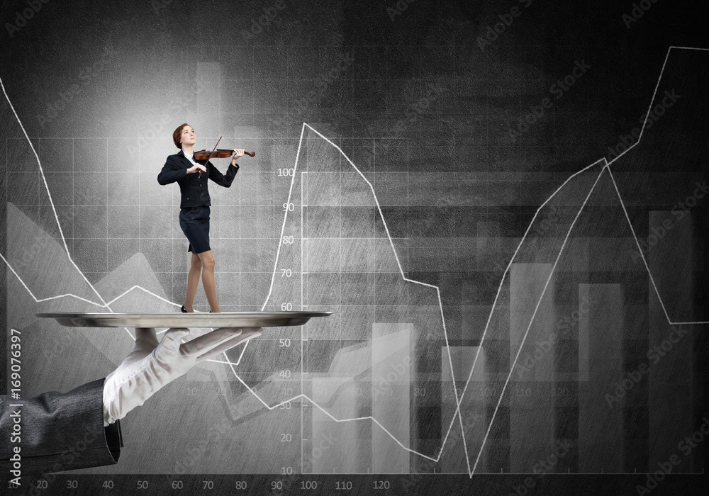 Attractive businesswoman on metal tray playing violin and graphs at background