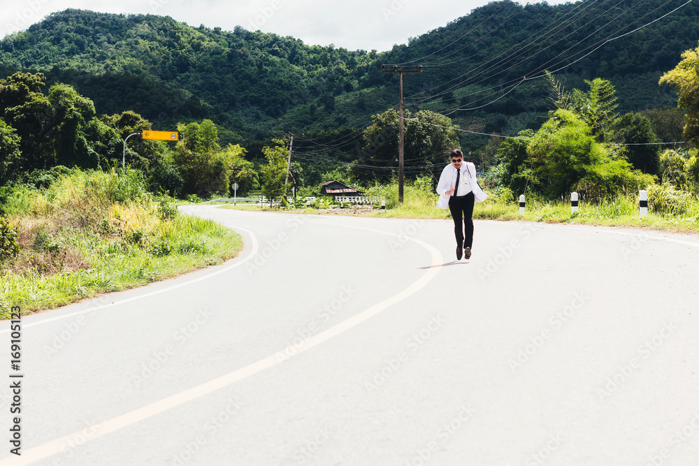 亚洲年轻医生在农村公路上跑步。偏远的社区卫生与发展医院