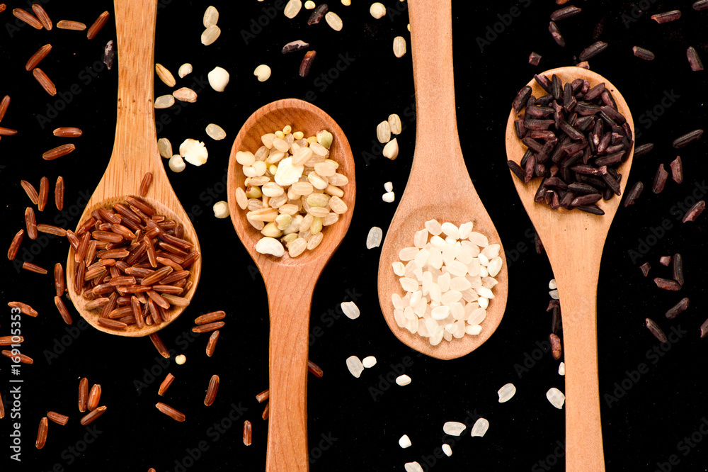 row of wood spoons with various rice：white rice,blck rice, red rice and grain rice