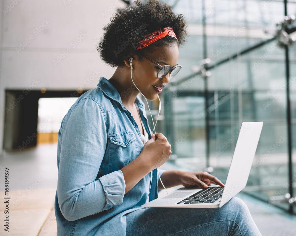 Young African female student working on a laptop on campus