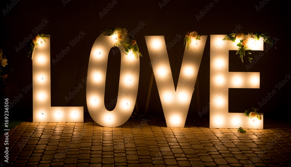 The inscription is love. Glowing large letters. Wedding decorations.