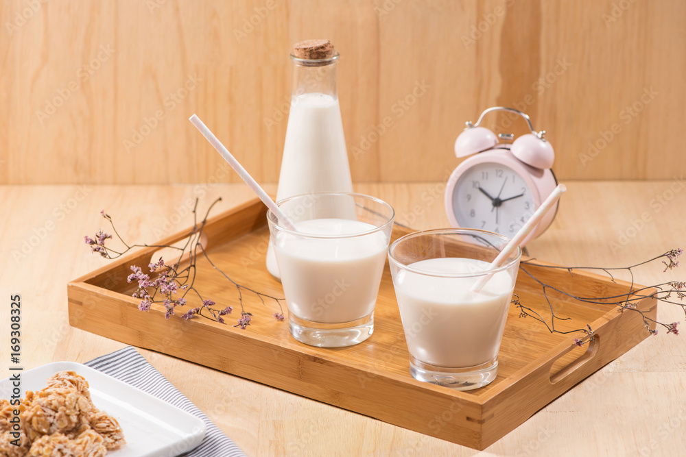 Dairy products. A bottle of milk and glass of milk serve with almond candies on a wooden table.