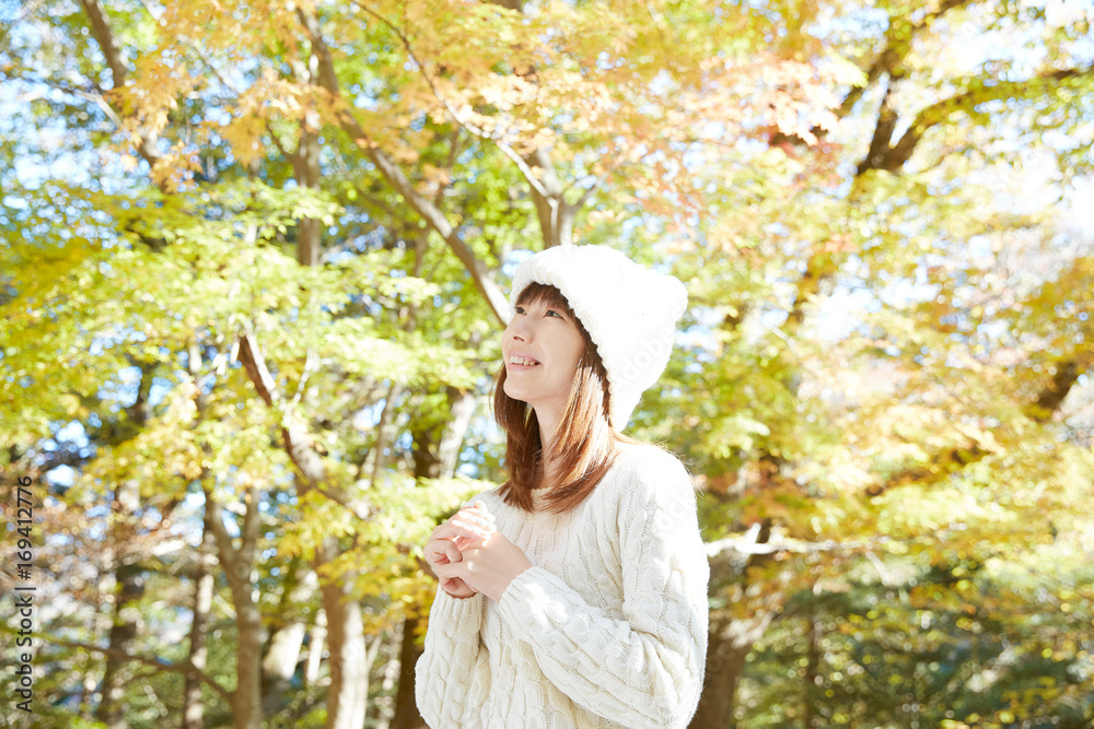 秋の紅葉の中の女性　笑顔