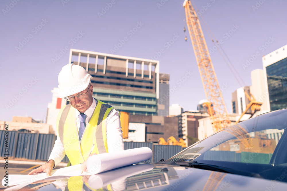 Senior foreman in glasses doing his job at building area on car 