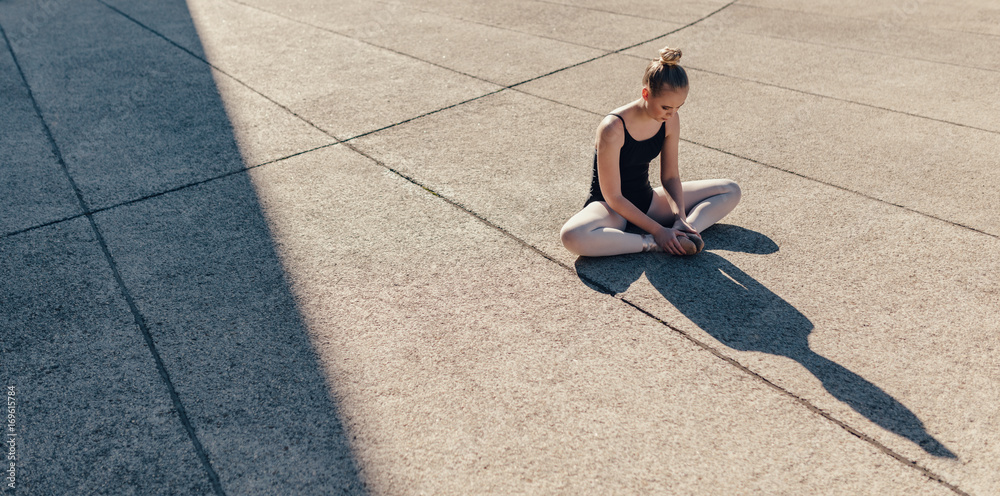 Female ballet dancer warming up before the practice