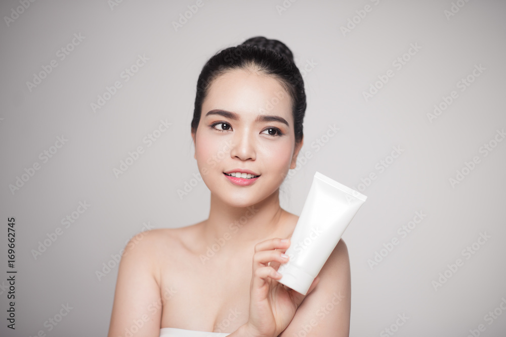 Beauty concept. Asian pretty woman with perfect skin holding cosmetic bottle