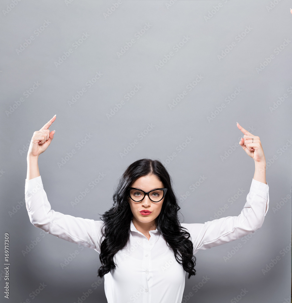 Young woman reaching and looking upwards a solid background