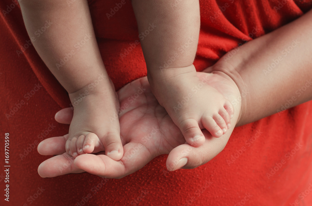 baby feet on mother hand