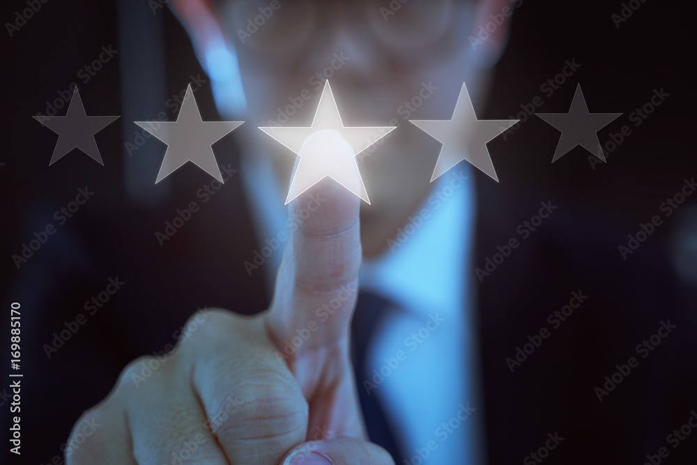 Young businessman touch the five star symbol to increase rating of company .