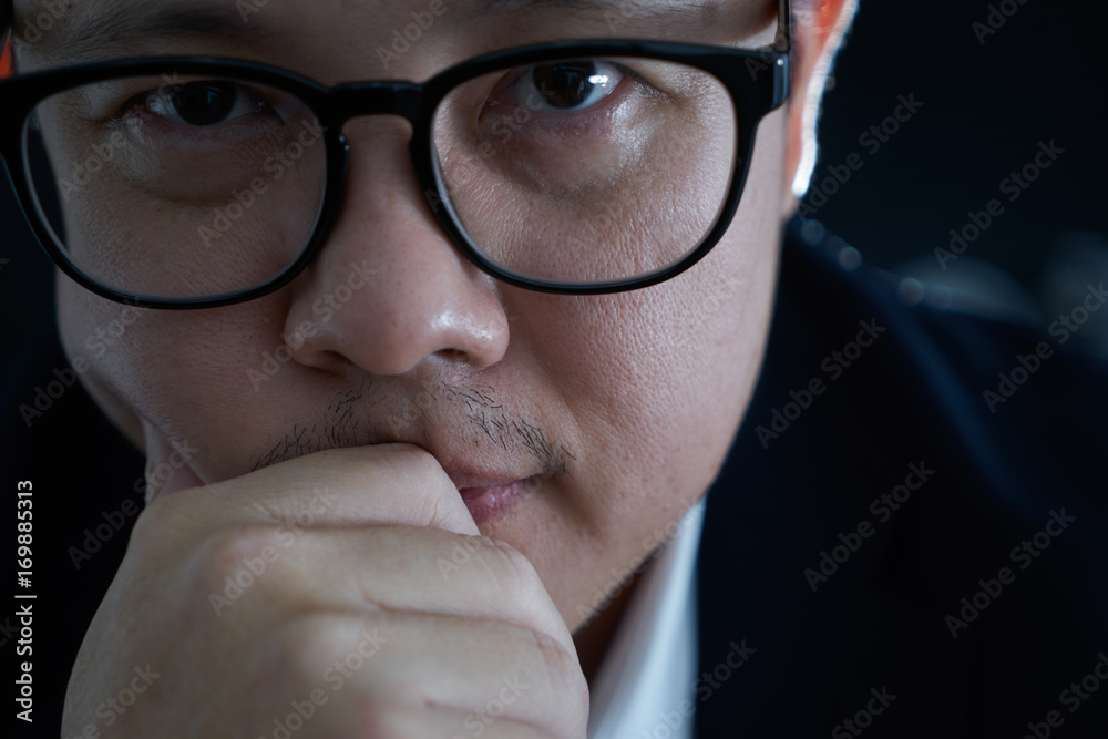 Portrait of serious young asian businessman looking at camera.