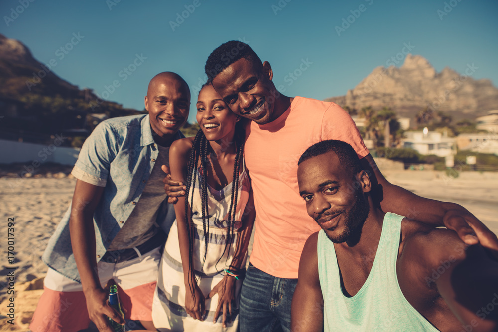 Group of friends taking selfie on the seashore.