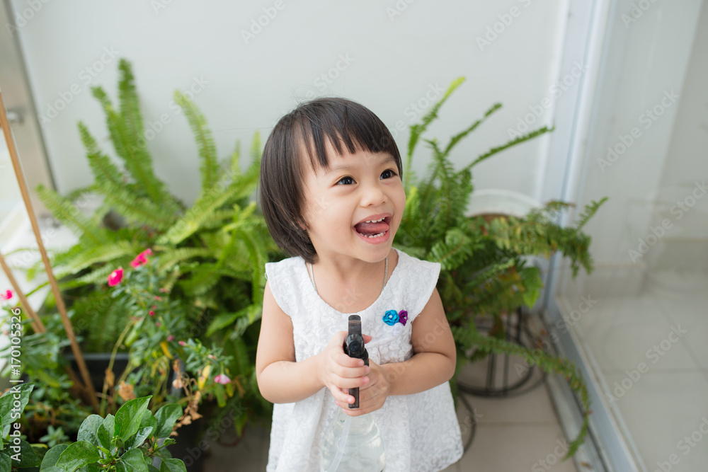 孩子在照顾植物。可爱的小女孩在浇花