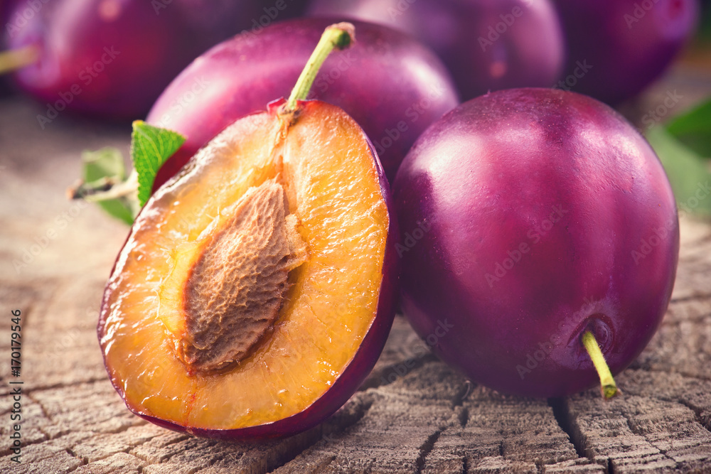 Plum. Juicy ripe organic plums closeup, over wooden background