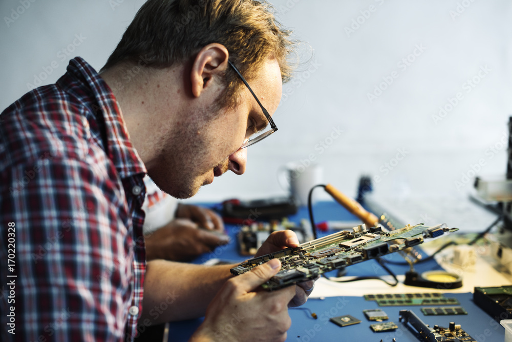 Side view of technician working on computer mainboard