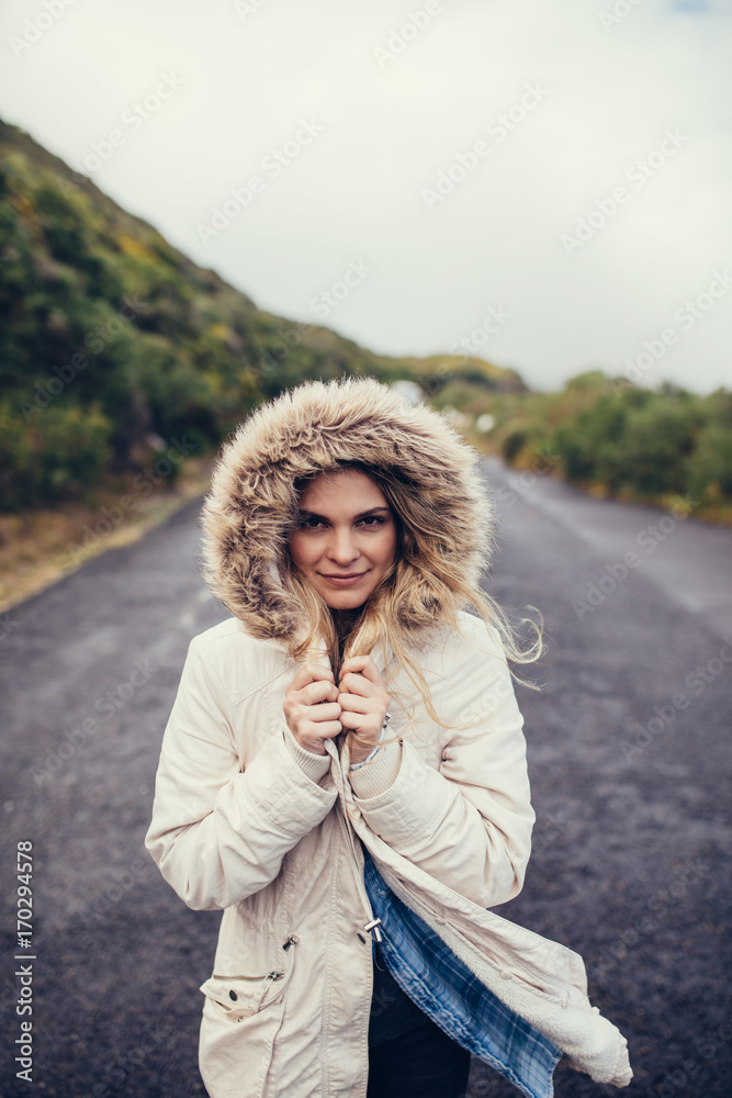 穿着保暖衣服的女人在开阔的道路上