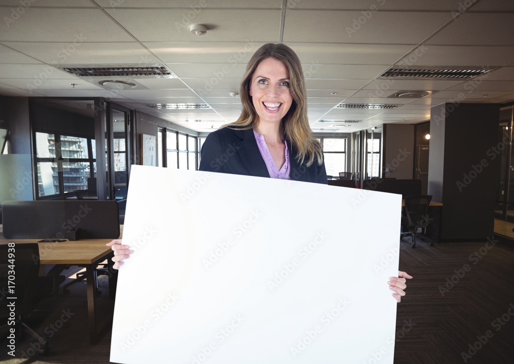 Happy business woman holding blank card in office