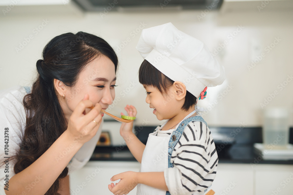 厨房里有一个幸福的家庭。母女俩正在准备蔬菜和水果。