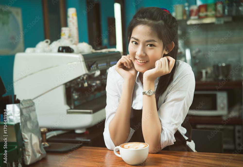 Woman Coffee shop owner Holding a glass of coffee in the cafe.