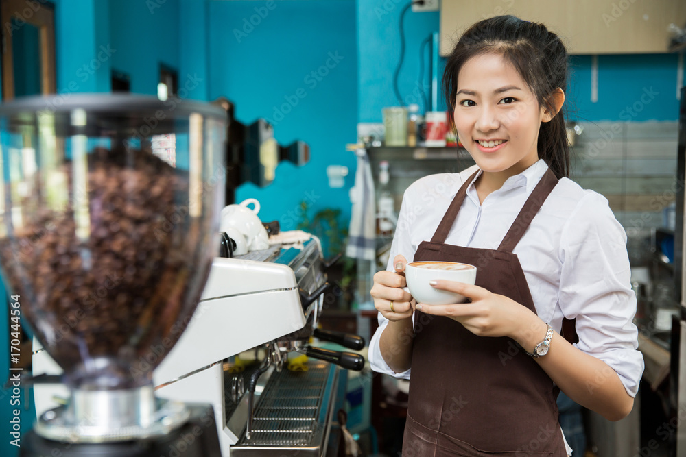 咖啡店老板在咖啡馆里拿着一杯咖啡