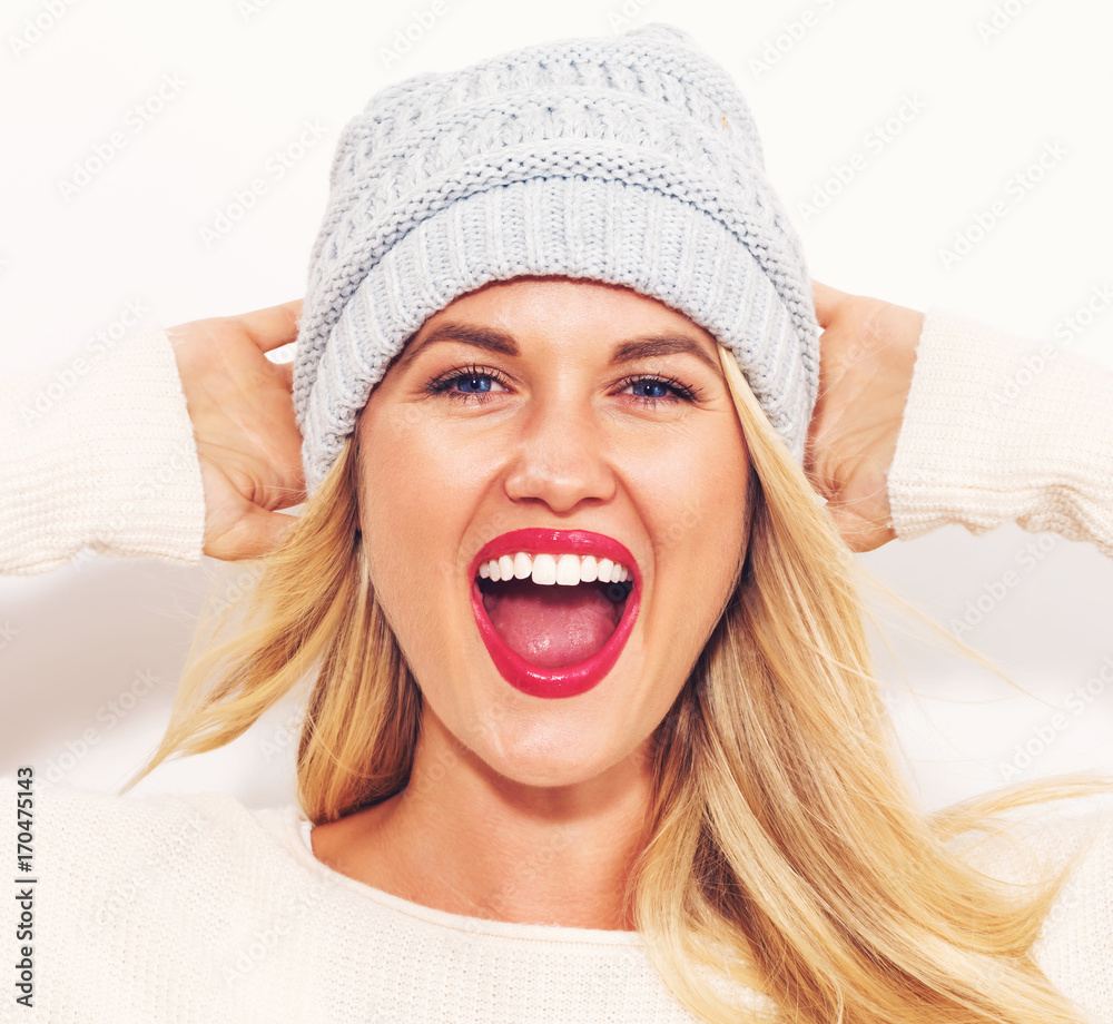 Happy young woman in winter clothes on a white background