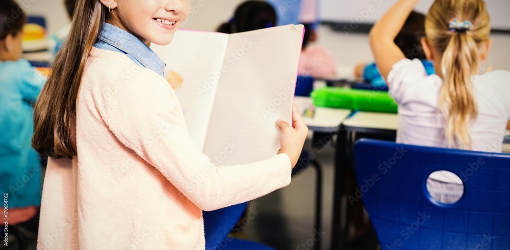 女学生拿着书站在教室里的肖像