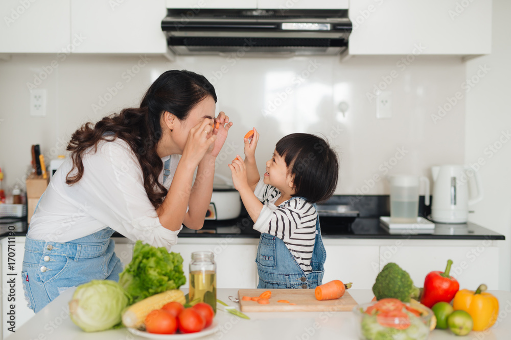 Mother with her daughter in the kitchen cooking together