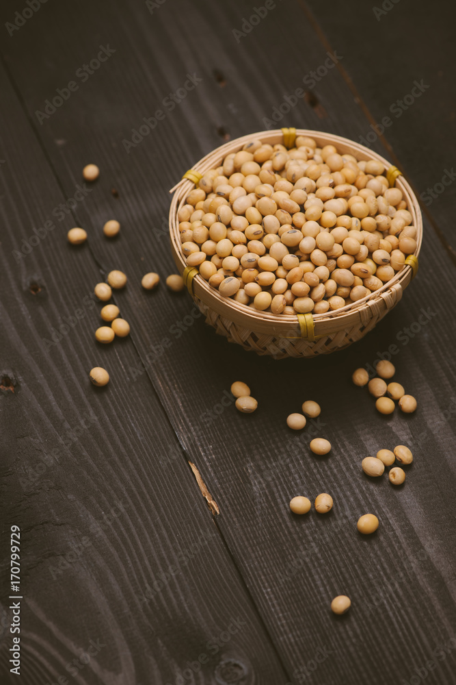 Soy beans in bowl on wooden background