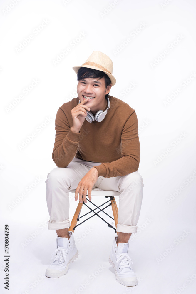 Smart casual asian man seated on chair, in studio background