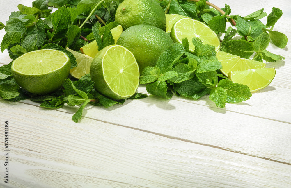 Limes and mint on wooden background. Top view with copy space